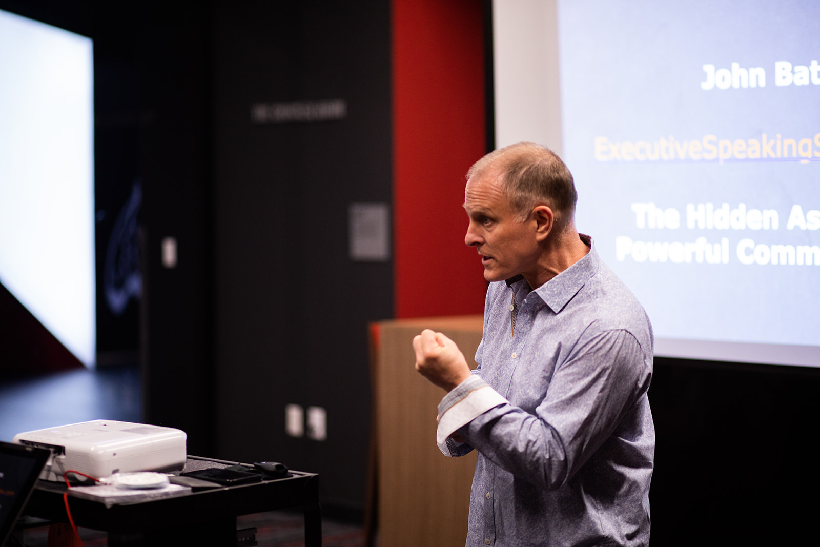 John K. Bates speaking with focused presence during an executive communication program